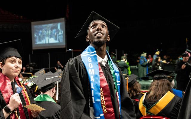 A student looks hopeful and excited at graduation. 