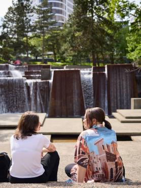 Students sitting in front of fountain
