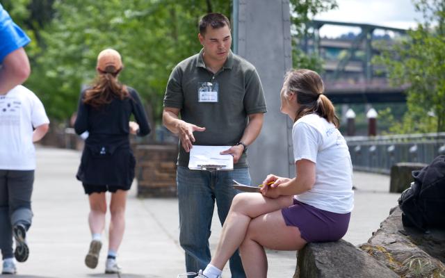 Student surveyer asking woman questions on trail