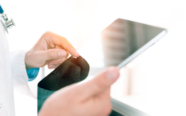 An image of a doctor's hands holding a tablet
