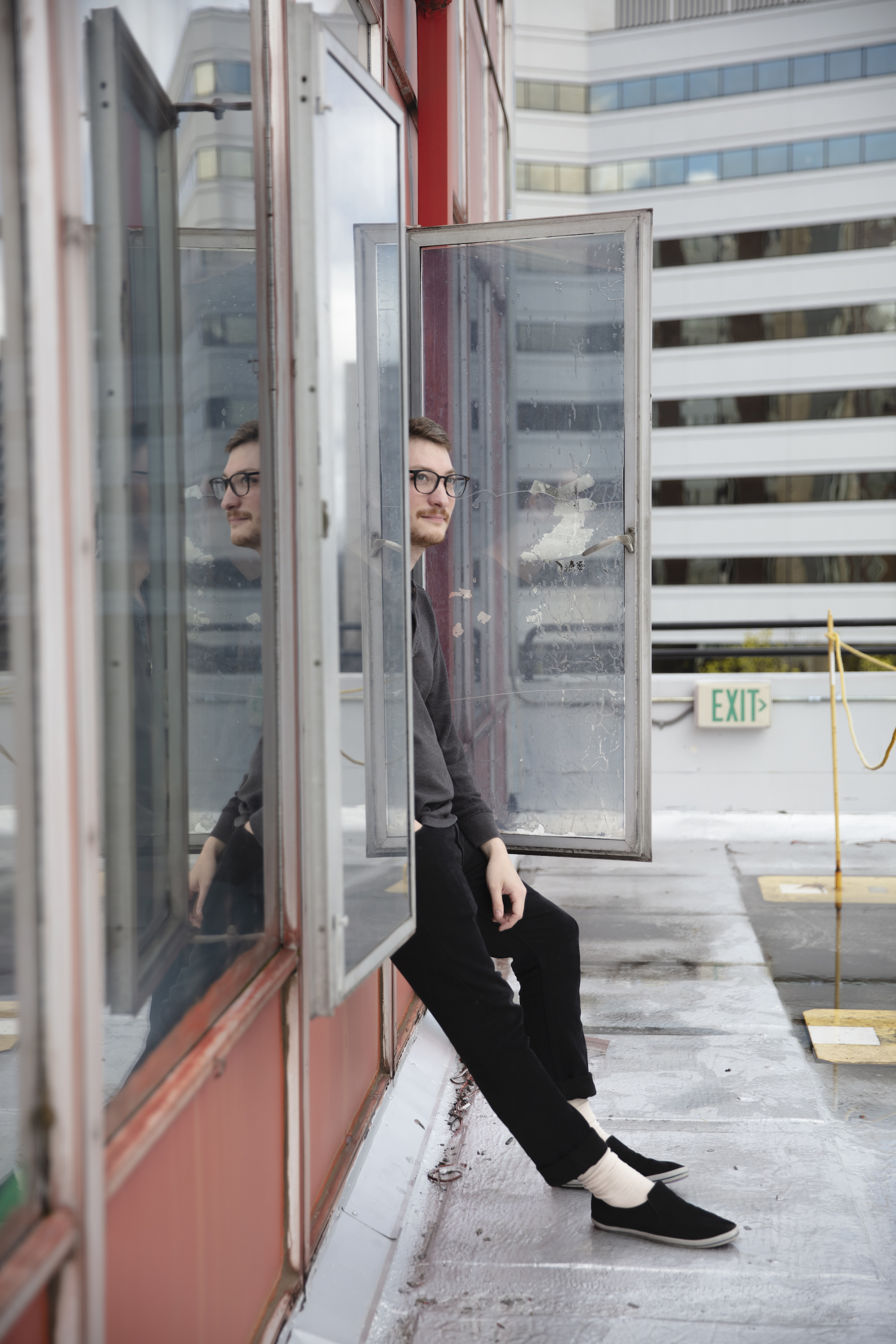 whimsical portrait of a graphic design student posing on the room of the art building