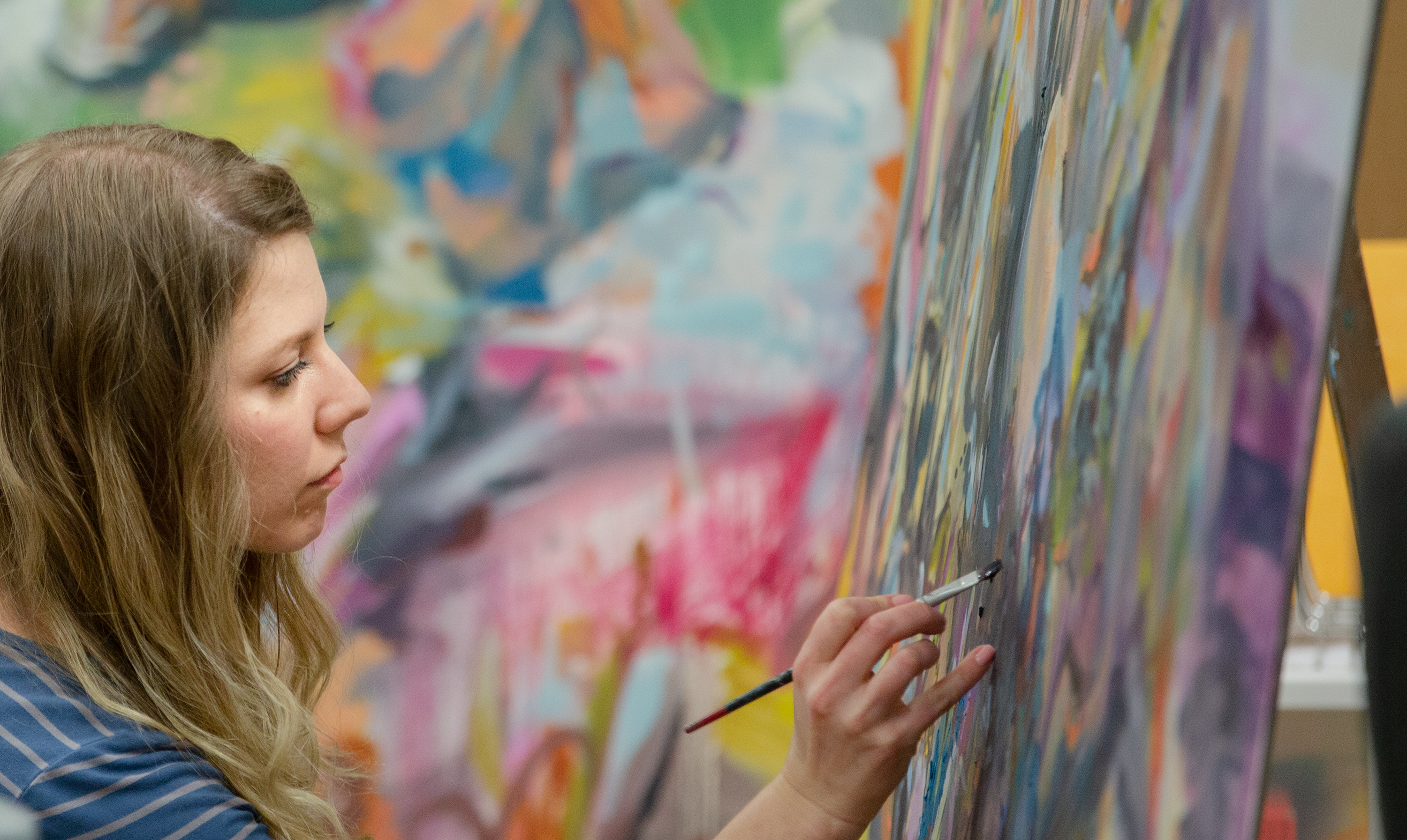 Student painting in an art studio