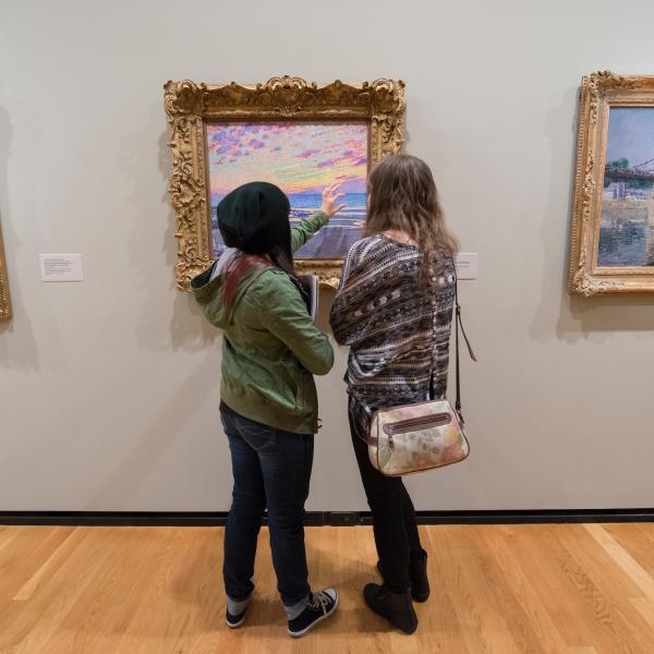 Art history students discussing a painting at the Portland Art Museum