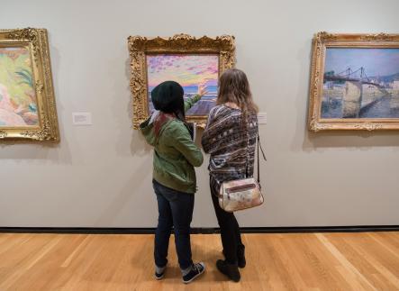 Art history students discussing a painting at the Portland Art Museum