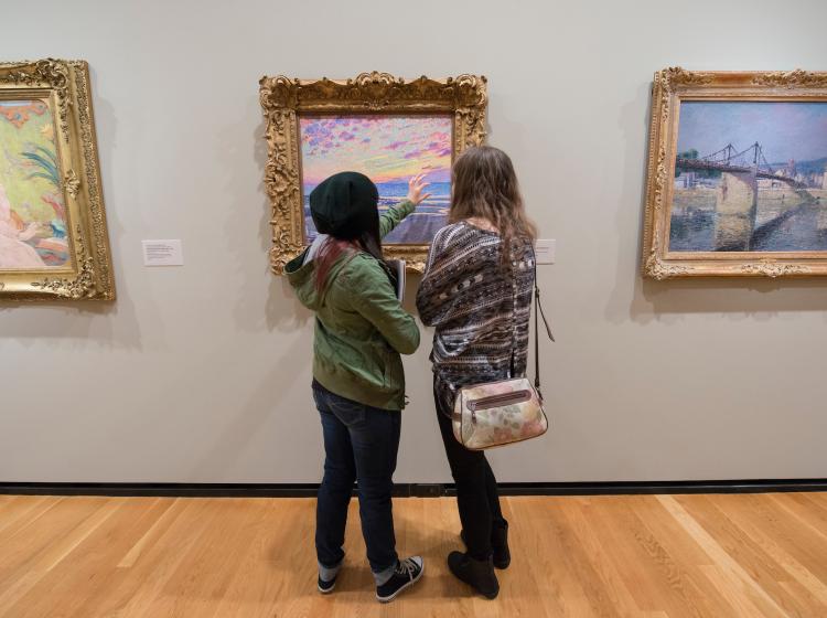 Art history students discussing a painting at the Portland Art Museum