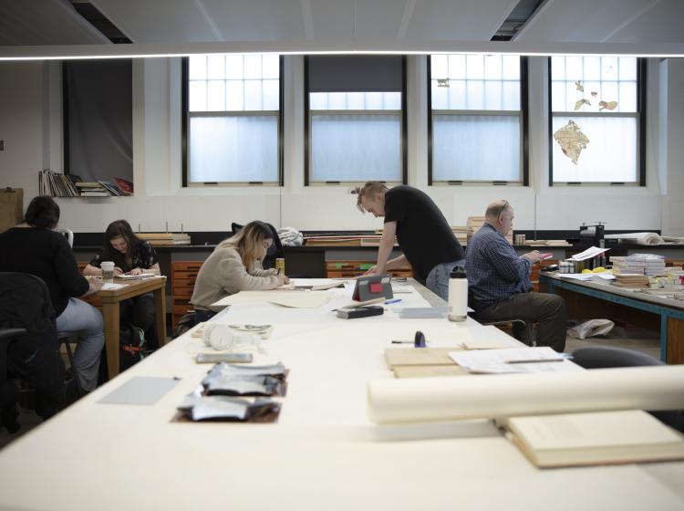 Students at work at tables in printmaking studio