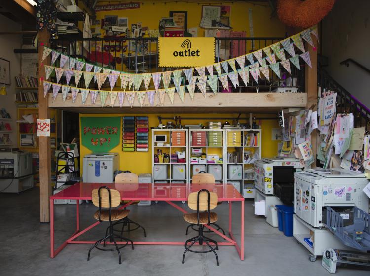 Interior of Outlet studio with large red communal table