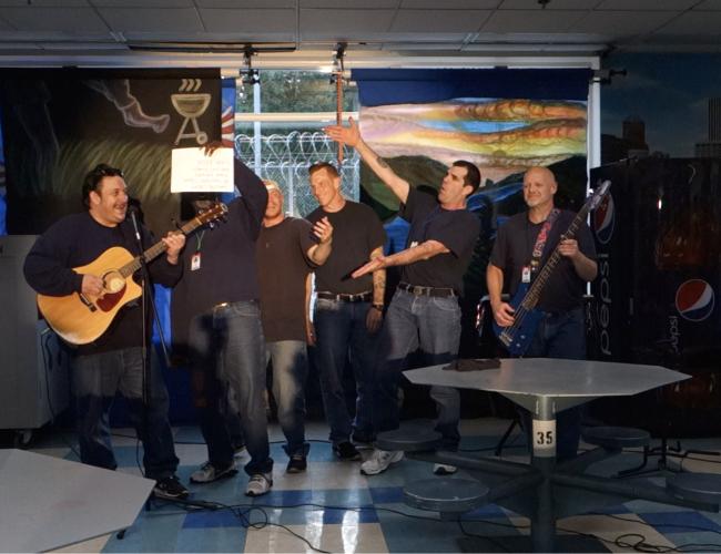 Six men, two with guitars, perform a comedy sketch at CRCI.