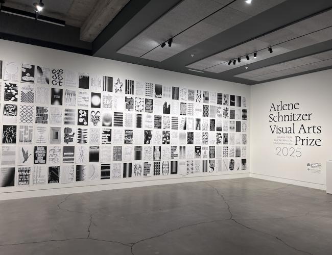 A gallery wall filled floor to ceiling with black and white posters featuring uplifting messages and designs.