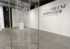 Installation view of crystal bead curtain hanging from a rectangular gold frame.