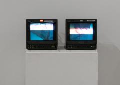Two video monitors, side-by-side, display a series of images of the artists and her grandmother.