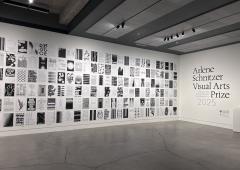 A gallery wall filled floor to ceiling with black and white posters featuring uplifting messages and designs.