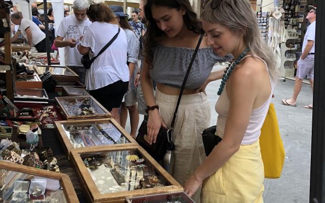 Two women shopping in an open air market in Italy.