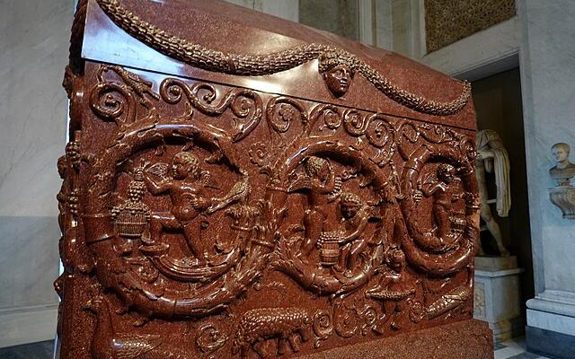 Sacrophagus of Constantinia. Polished purple/red stone with carvings of cupid and grape vines.