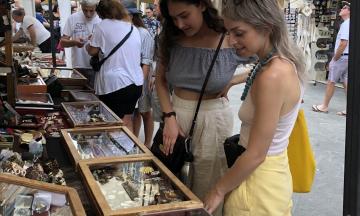 Two women shopping in an open air market in Italy.