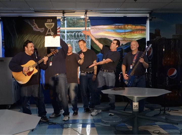 Six men, two with guitars, perform a comedy sketch at CRCI.