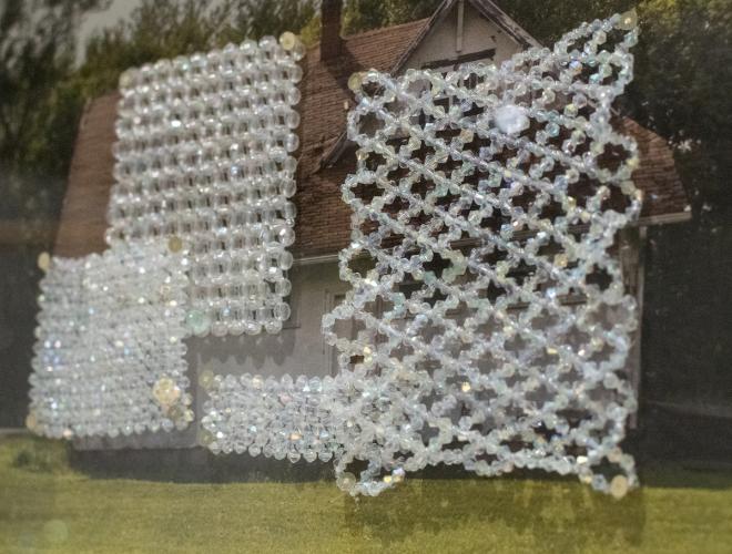 Photograph of a house with woven crystal bead overlaid.