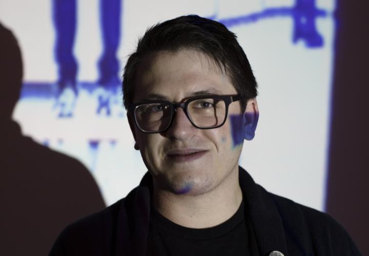 Graduate student Alex Woodward in gallery with video projection