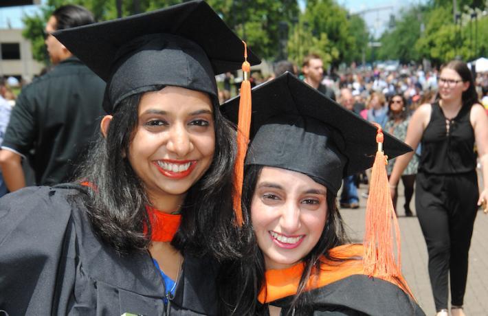 Image of two graduate students at graduation