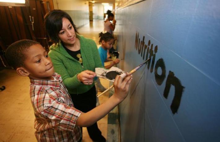 Image of Student with child painting