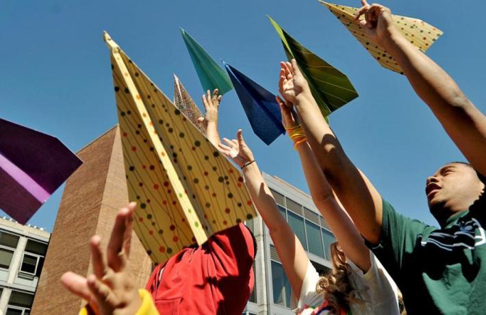 Image of students throwing colorful paper planes 