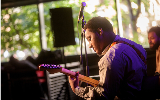 Image of a guitar performer playing a show in the Smith building 