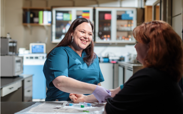 Image of a nurse giving a student a shot,