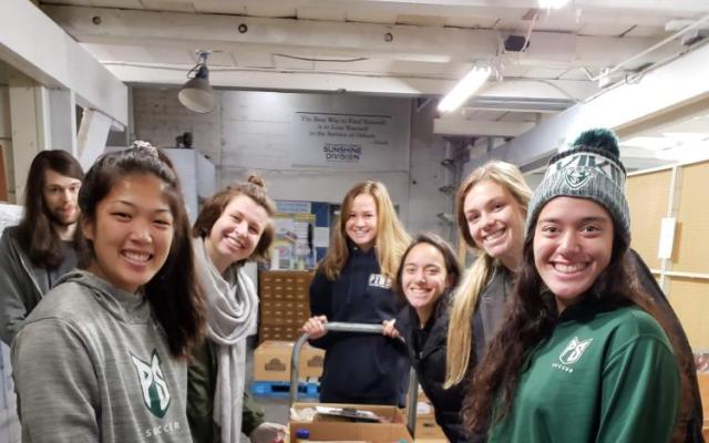 Image of student volunteers helping pack food boxes with the Sunshine Division.
