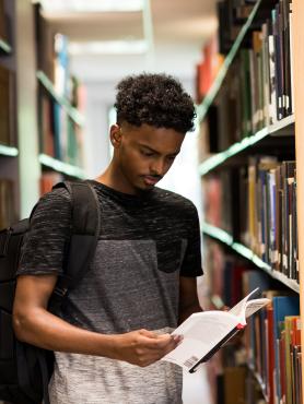 Student reading a book at the library