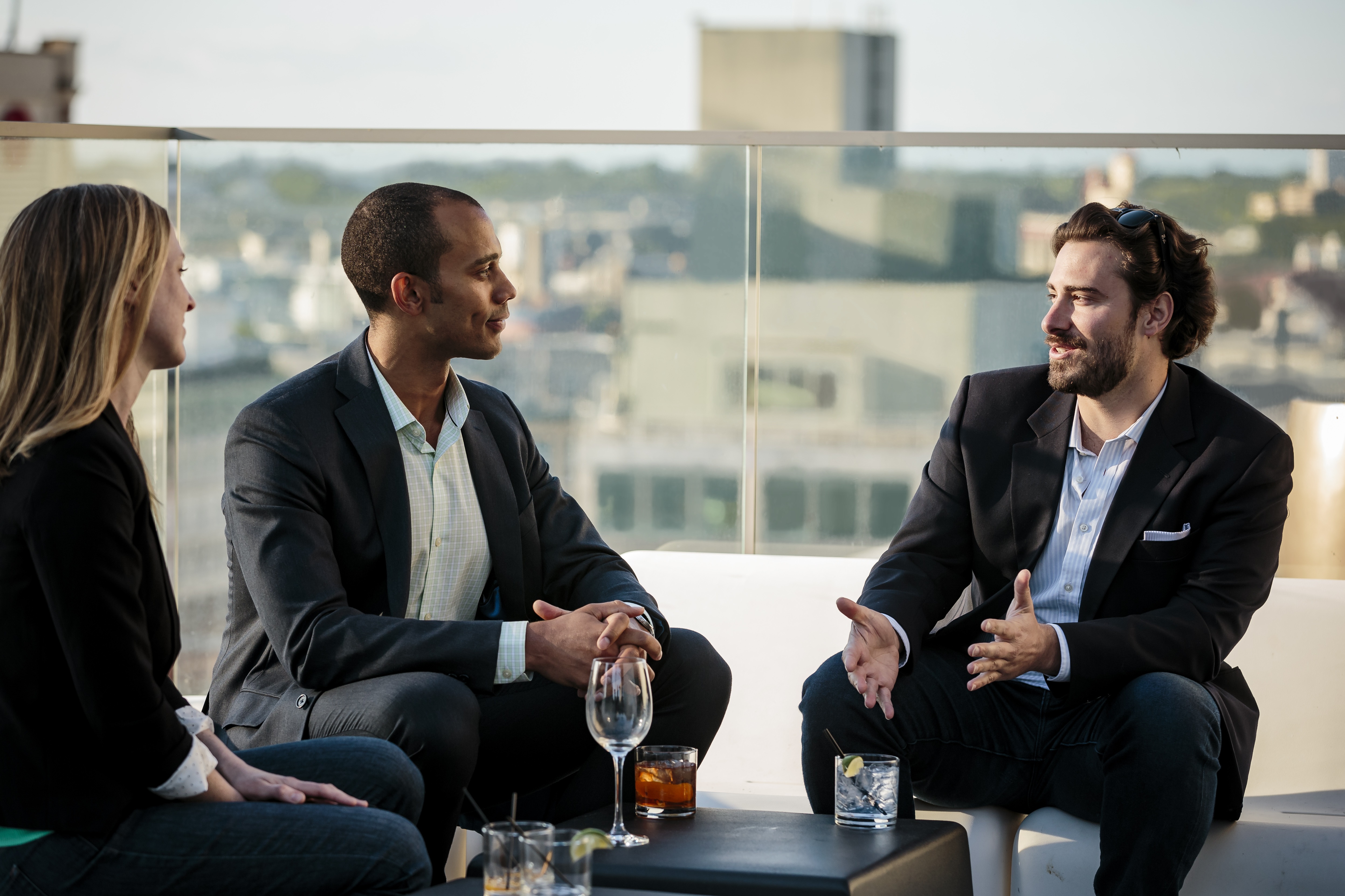 Three people talking with city in background