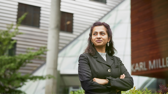 Student standing with arms crossed in front of KMC