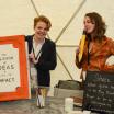 Two women tabling at the Elevating Impact Summit. 