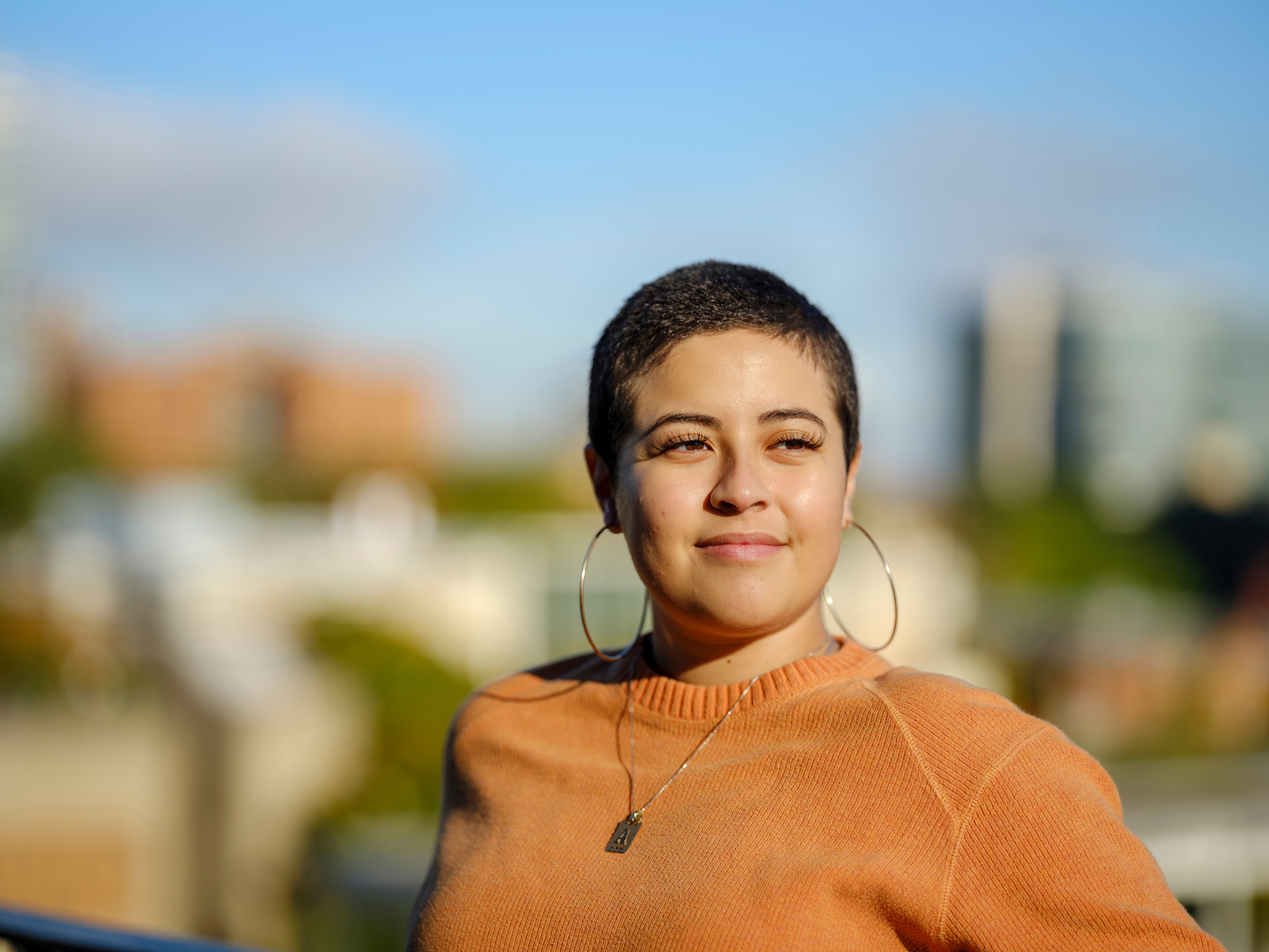 student posing in front of cityscape