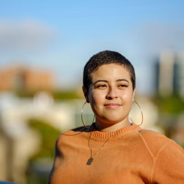 student posing in front of cityscape