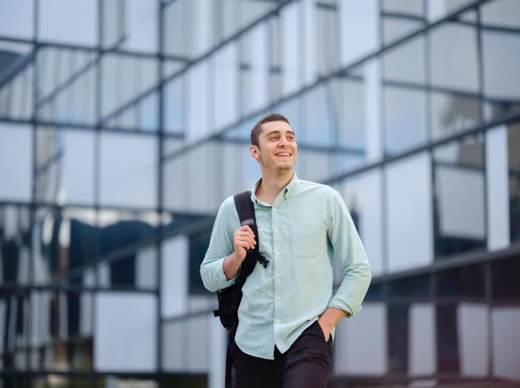 Student dressed business casual walking through campus