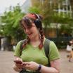 Student listening to headphones and exploring their phone