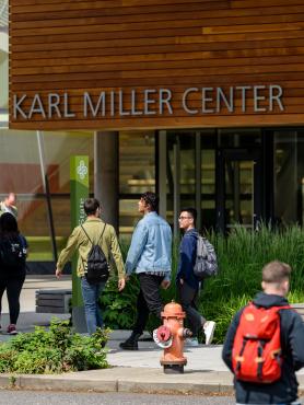 A group of students walking past the Karl Miller Center.