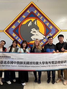 Teachers holding up sign at local middle school visit