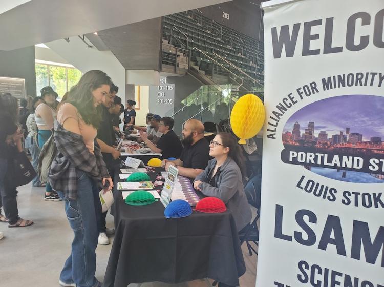 Student talking to LSAMP program representative at the 2023 SRA