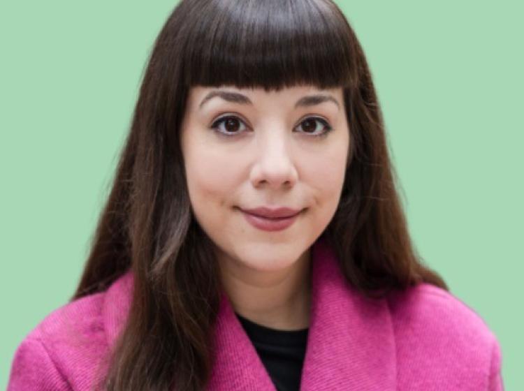 Brunette woman in magenta blazer smiling at camera