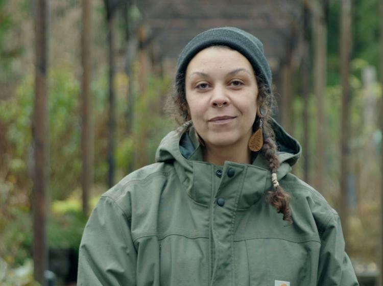 Nikita Vincent standing in green coat in on her farm