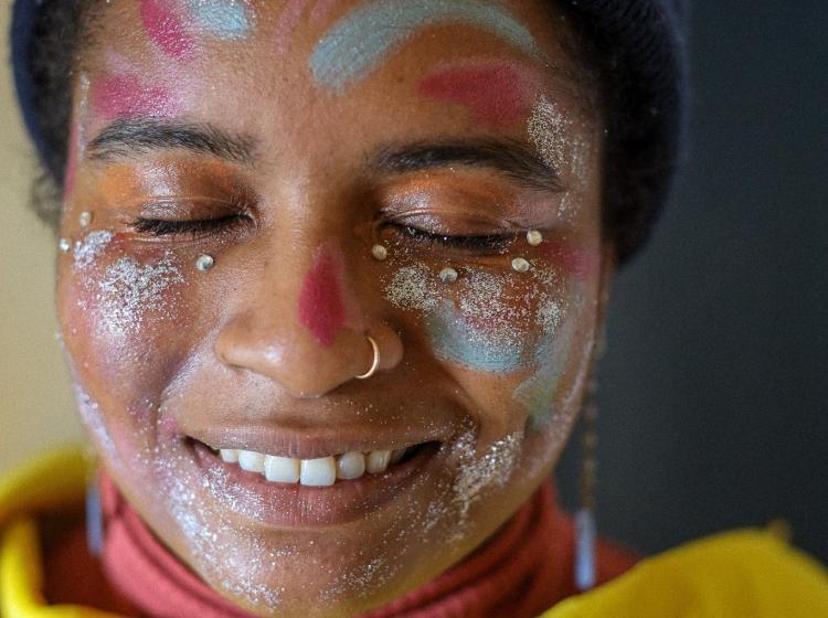 Zoe Gamell Brown, face covered in paint with eyes closed.