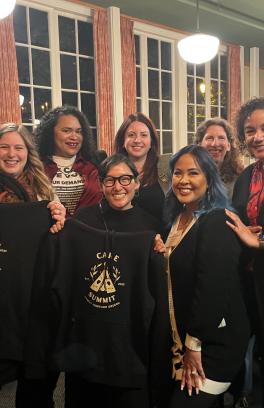 Care Summit organizers holding up conference sweatshirts and smiling 