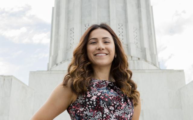 woman posing in front of a white building