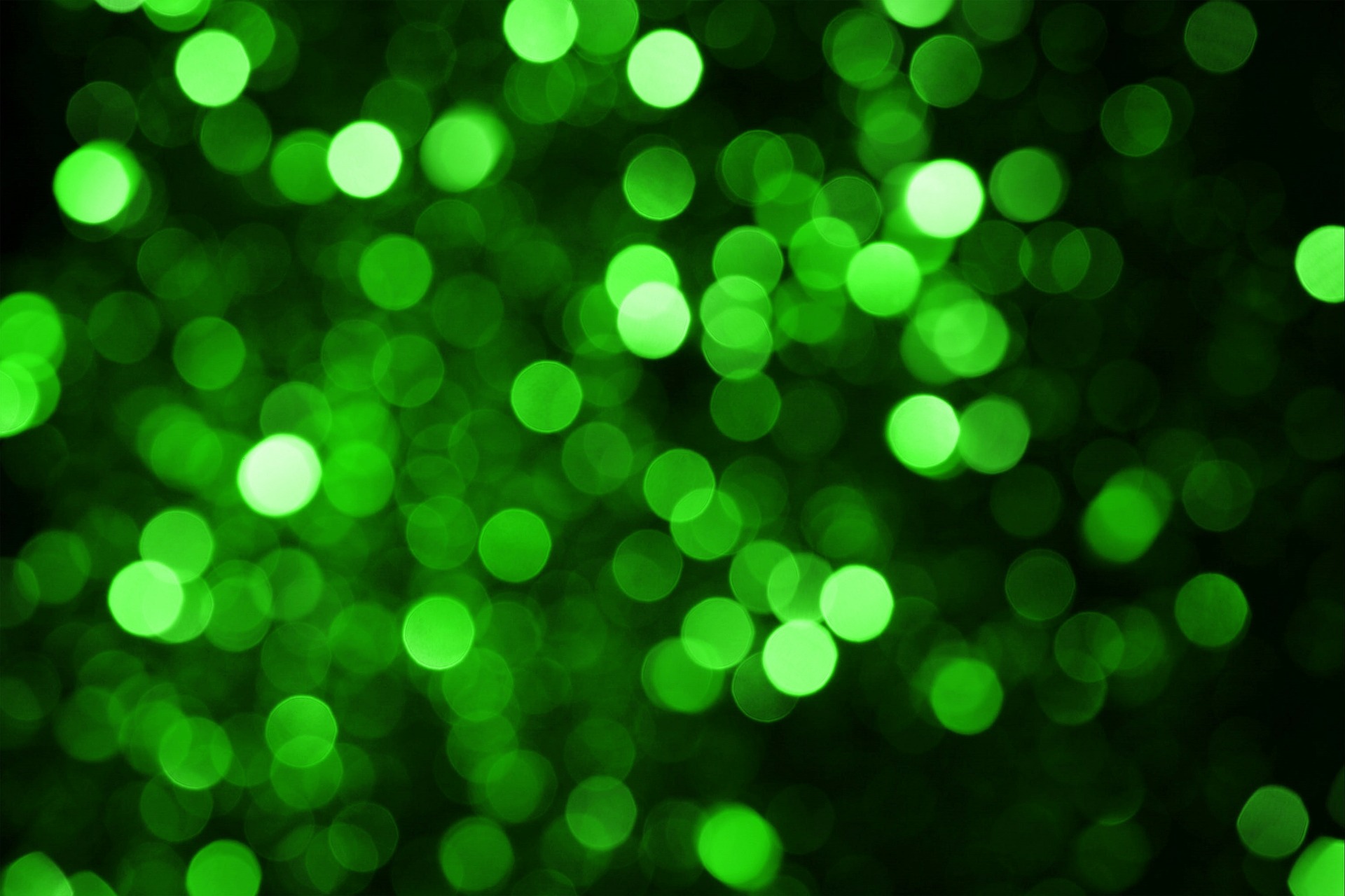 Green shiny circles on a black background.