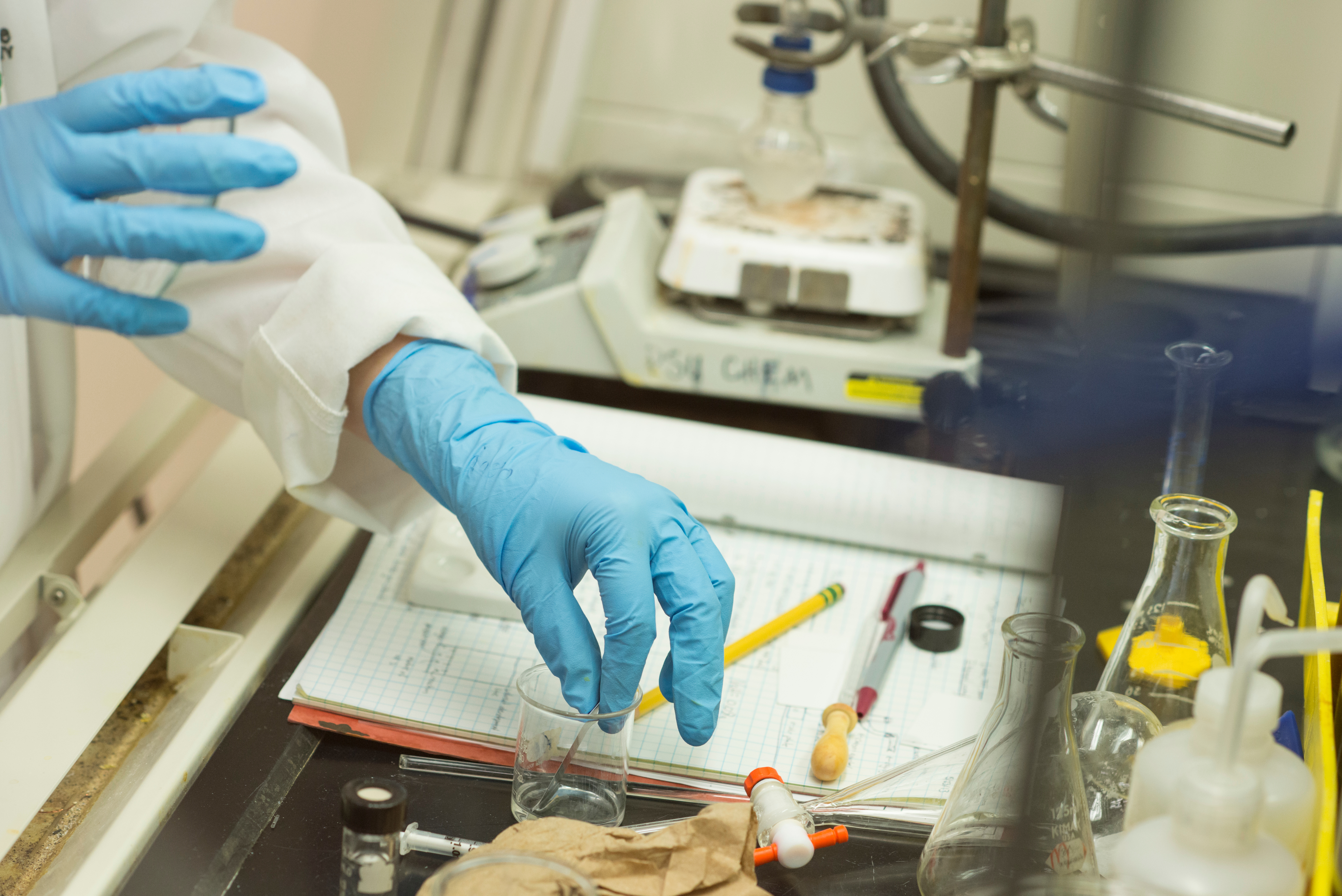 Close up of student hands doing chemistry experiment in lab
