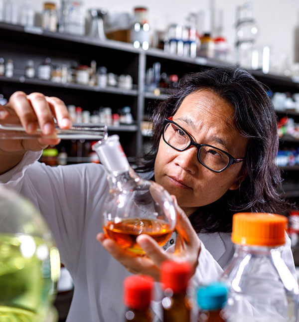 Jane Kelly pouring solution from test tube into a flask