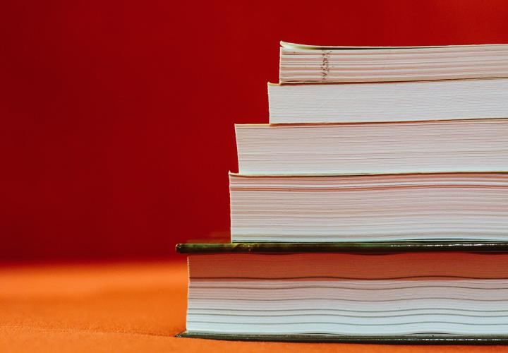 A stack of five books is shown. No titles are visible.