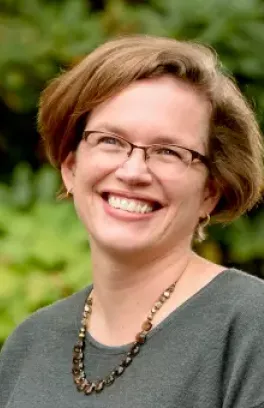 Anne Bentley, a white woman with short red hair, smiling.