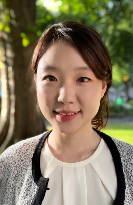 Sieun Chae, a young asian woman with long brown hair pulled back from her face smiling a the camera.